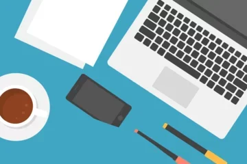 Open laptop and writing utensils, cup of coffee on a desk