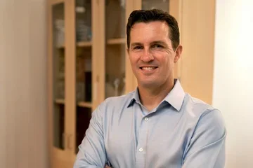 Dr. David Shackelford smiling and standing in his lab