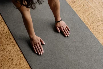 female hands touching a yoga mat