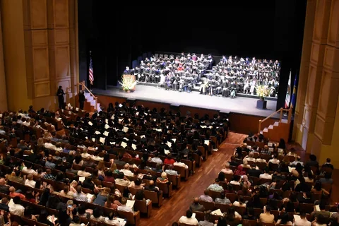 Royce Hall audience and stage filled with people in graduation regalia