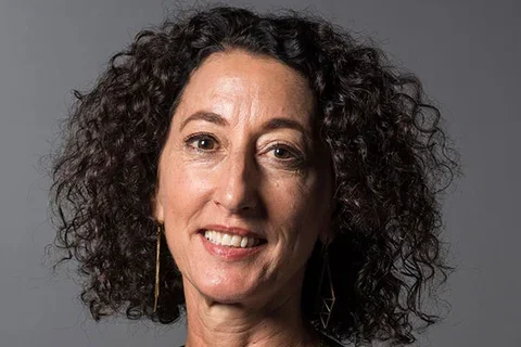 Woman with curly brown hair smiling
