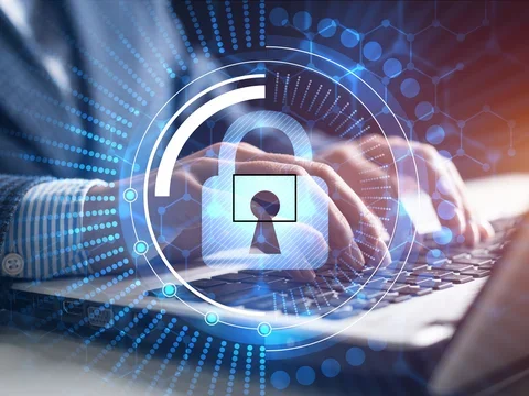 Lock superimposed over a person working on a laptop