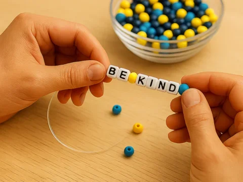 hands creating beaded bracelet