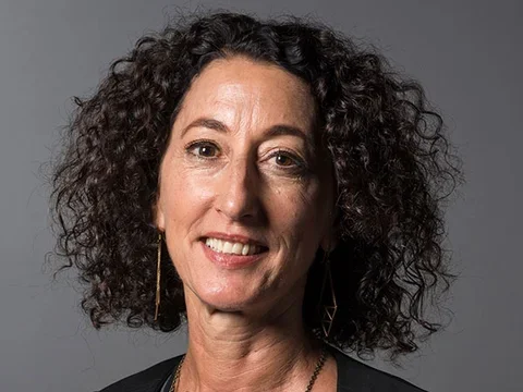 Woman with curly brown hair smiling