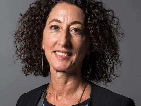Woman with curly brown hair smiling